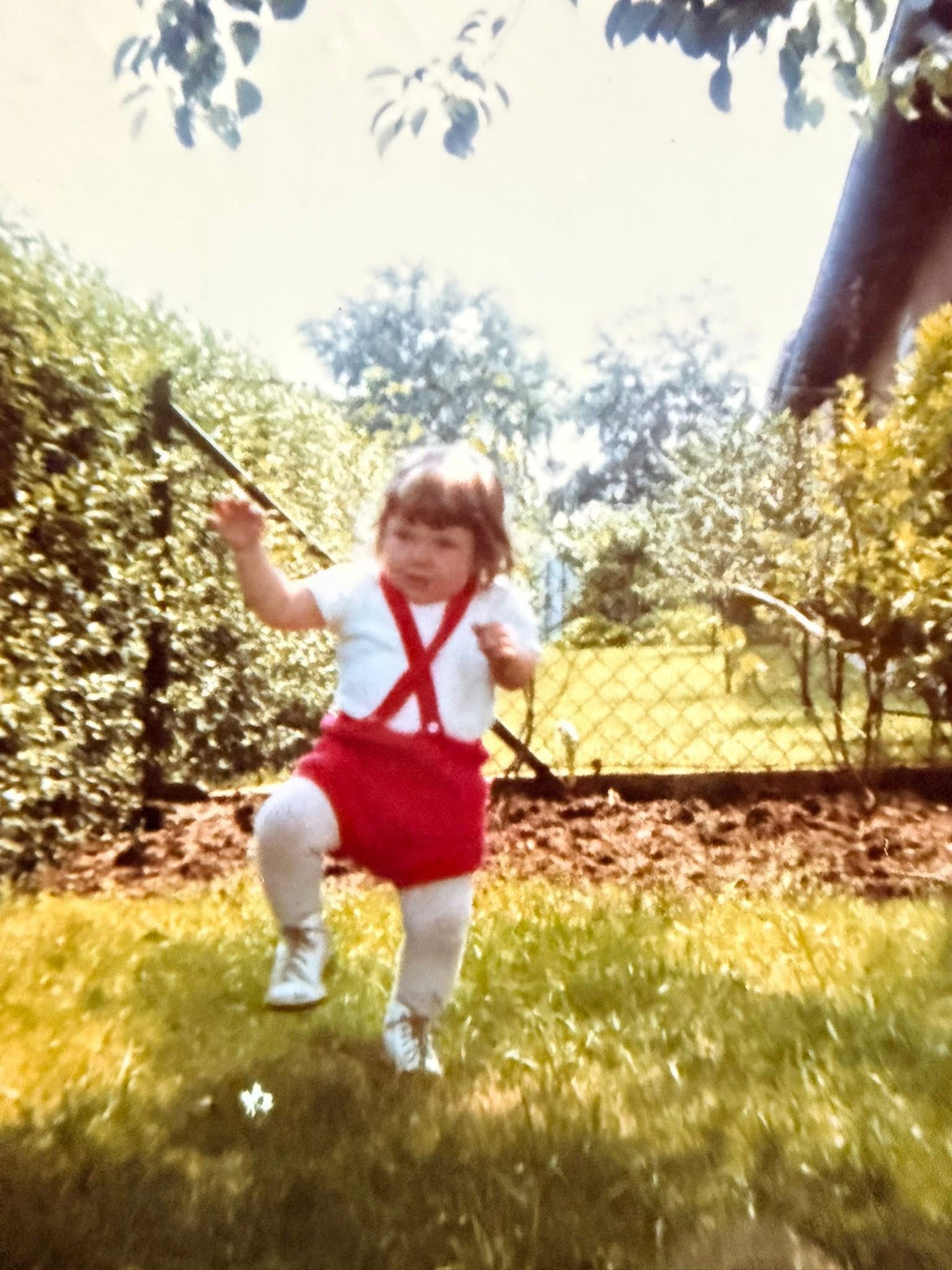 Manuela als kleines Kind auf einer Schaukel