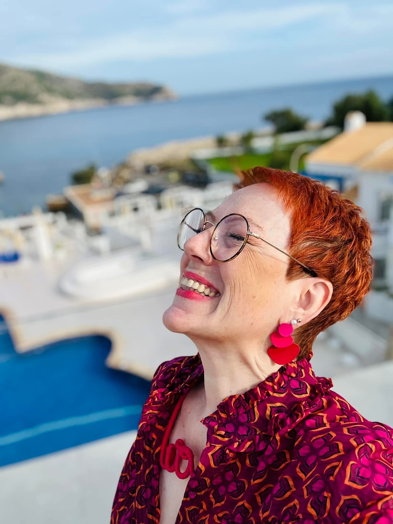 Manuela lacht mit dem Meer im Hintergrund
