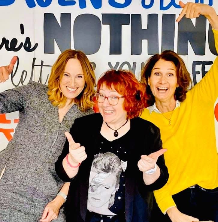 Manuela und zwei Frauen mit erhobenen Daumen und Armen