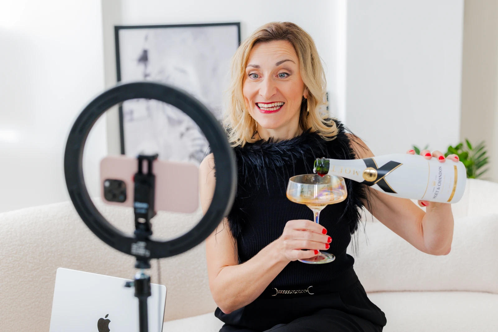 Contentaufnahme mit Smartphone und Ringlicht Jacqueline Schürer gießt vor einem Smartphone mit Ringlicht ein Getränk für eine Content-Aufnahme ein