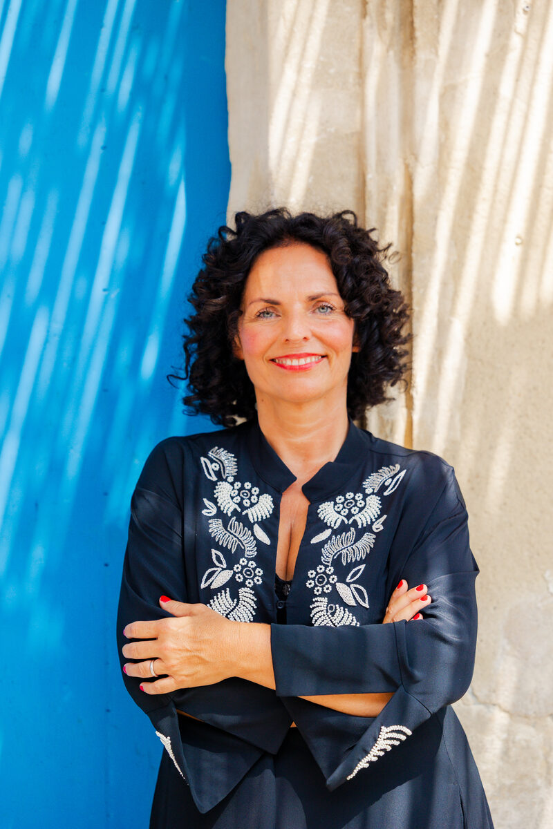Portrait vor blauem Vorhang Eine Frau im blauen Hemd vor einem blauen Vorhang