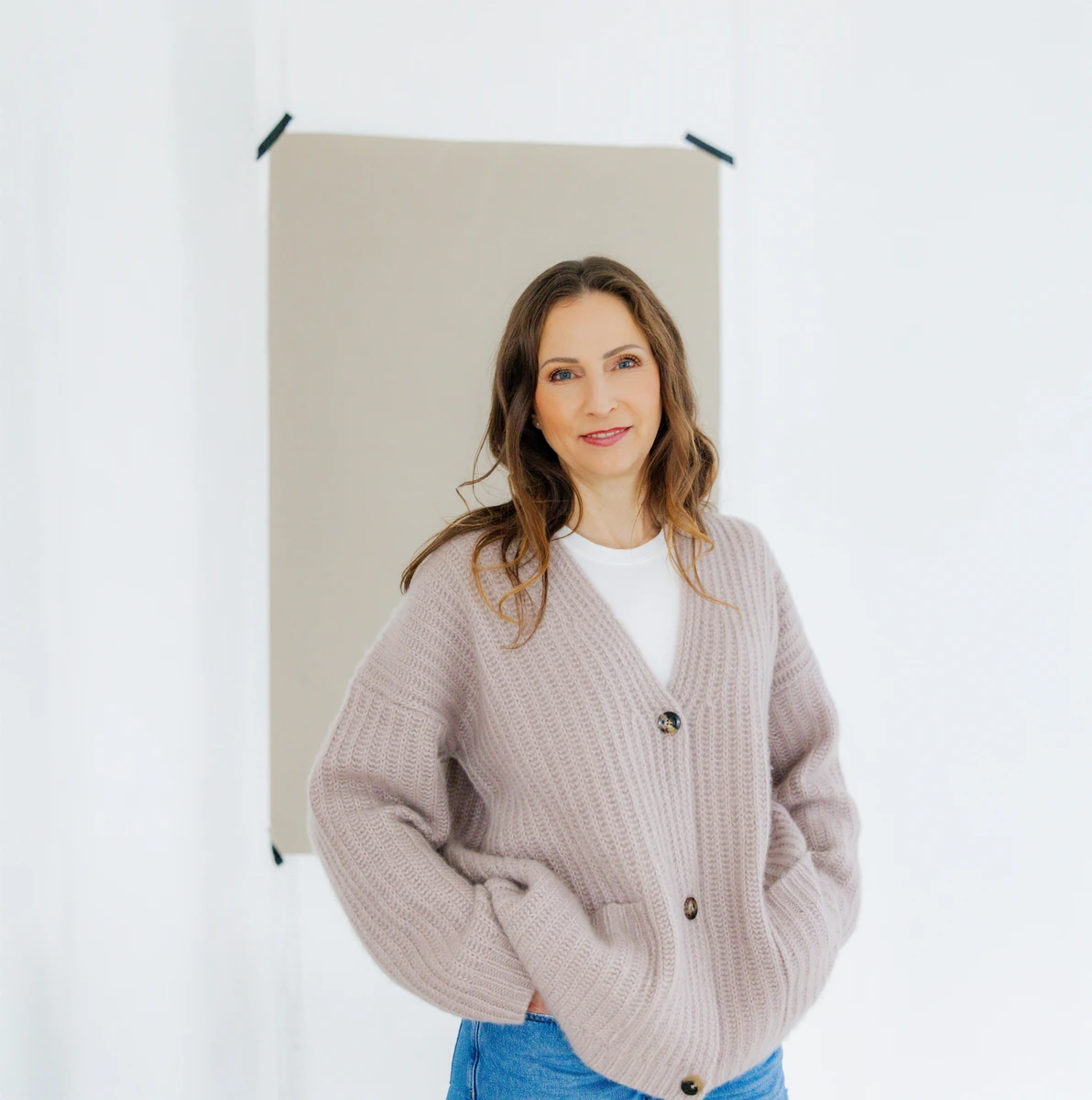 Anwältin und Coachin steht im hellen Strickpullover. Fotografin: Manuela Engelking. Aufnahmeort: Hamburg im Studio.
