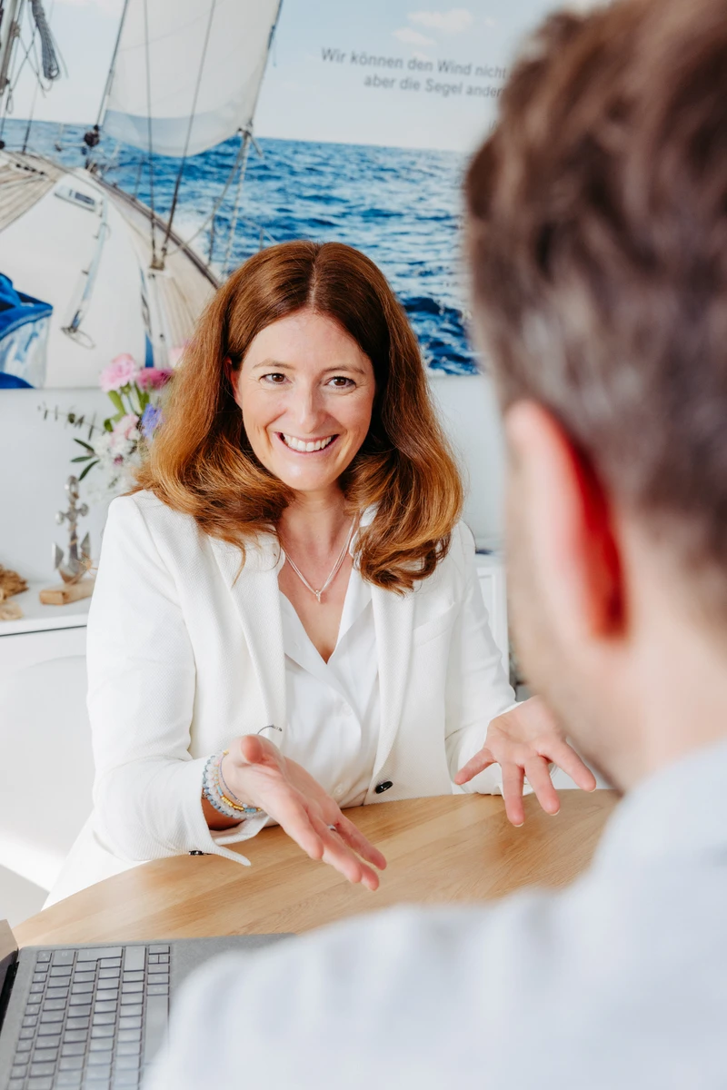 Unternehmerin im Kundengespräch Unternehmerin im weißen Blazer spricht mit einem Kunden. Fotografin: Manuela Engelking. Aufnahmeort: Frankfurt.