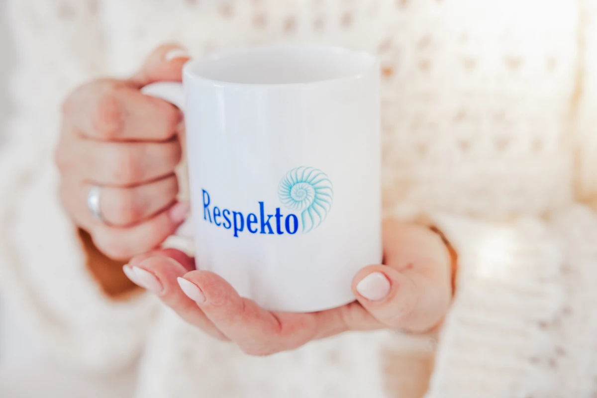 Hände halten eine Tasse mit Respekto-Schriftzug. Fotografin: Manuela Engelking. Aufnahmeort: Palma auf Mallorca.