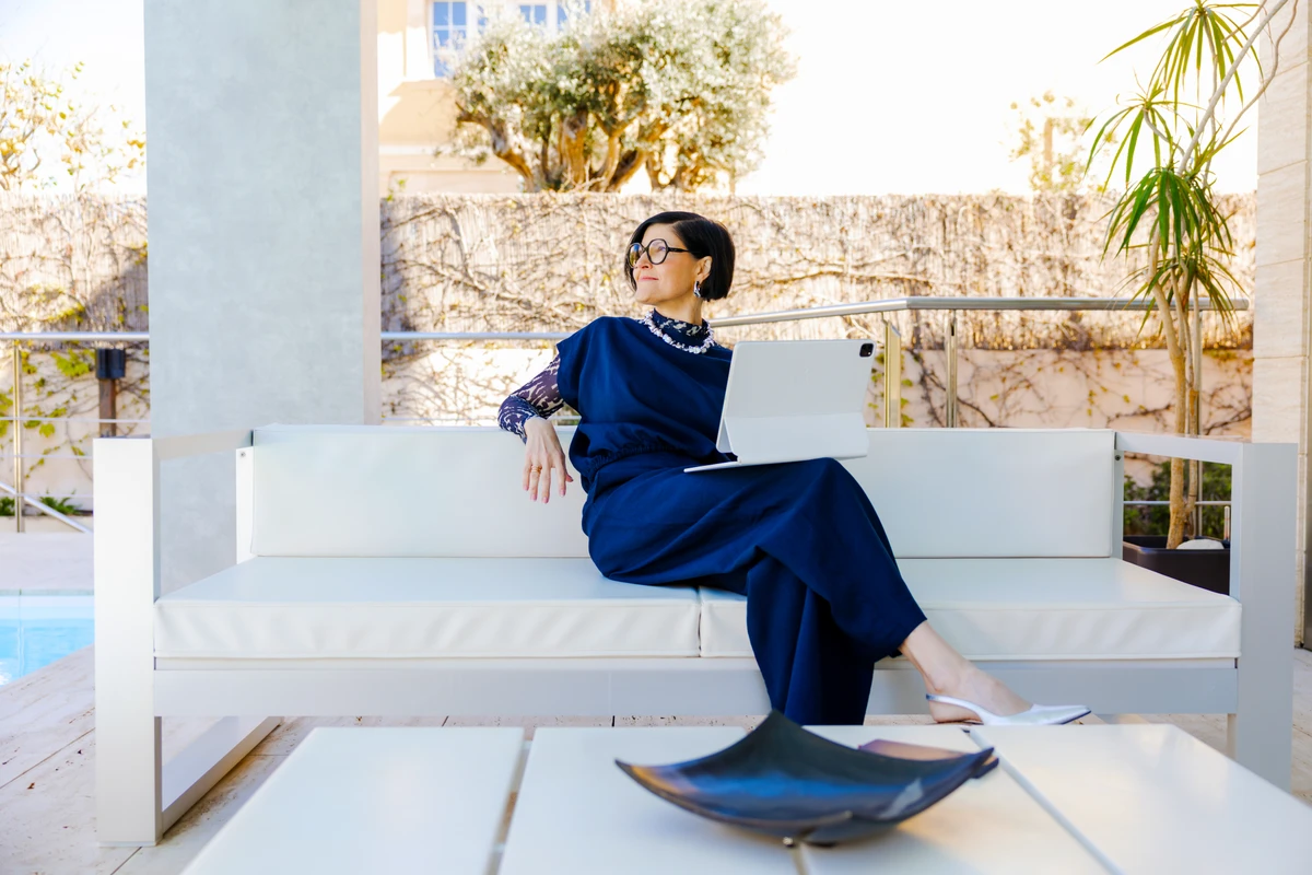 Unternehmerin sitzt mit Tablet auf einem weißen Sofa. Fotografin: Manuela Engelking. Aufnahmeort: Mallorca.