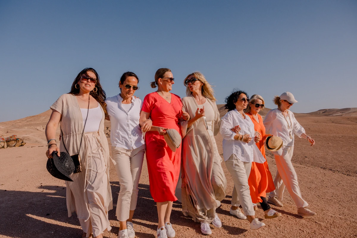 Gemeinsamer Weg durch die Wüste Gruppe von Frauen geht gemeinsam durch eine sonnige Wüstenlandschaft